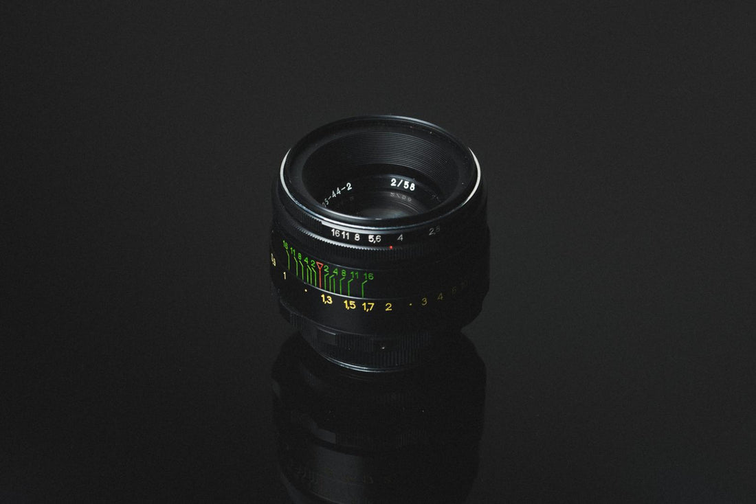 A close-up photograph of the Helios 44-2 vintage Soviet lens, showcasing its metal construction, aperture ring, and distinctive markings. The lens is known for its swirly bokeh effect and classic design, popular among photographers and collectors.